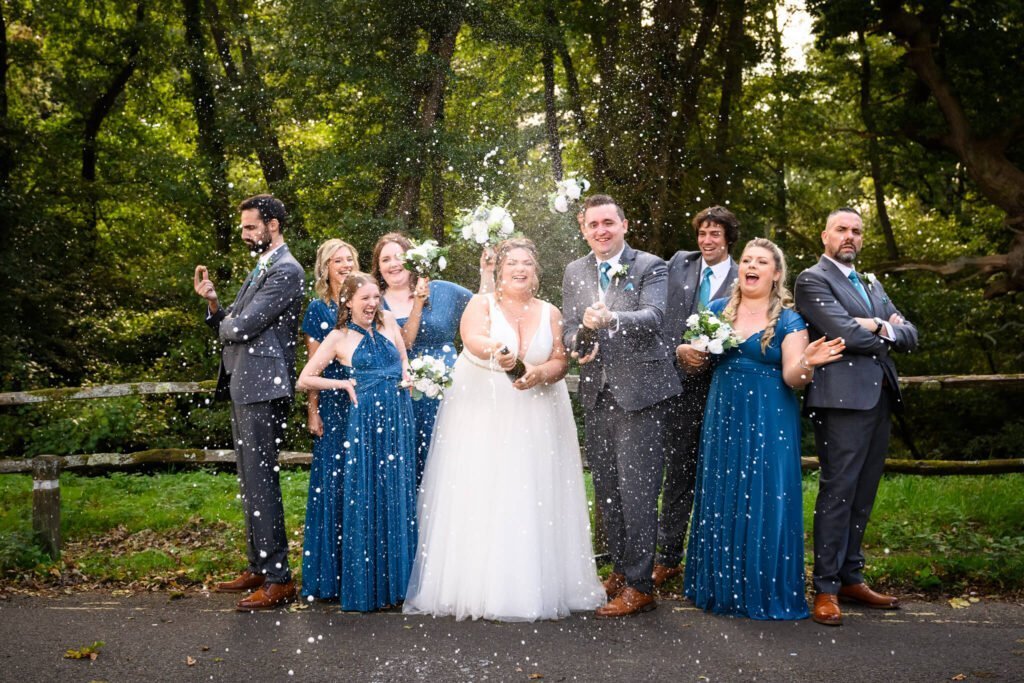 bridal party spraying champagne in celebration of the new bride and groom.