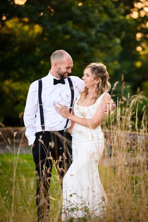 image of a Bride and groom, enjoying a rare moment alone on their wedding day. The light is beautiful and golden with warm light reflecting off the trees in Sussex country side. image captured by sussex wedding photographer Paul Streeter-Staniford.